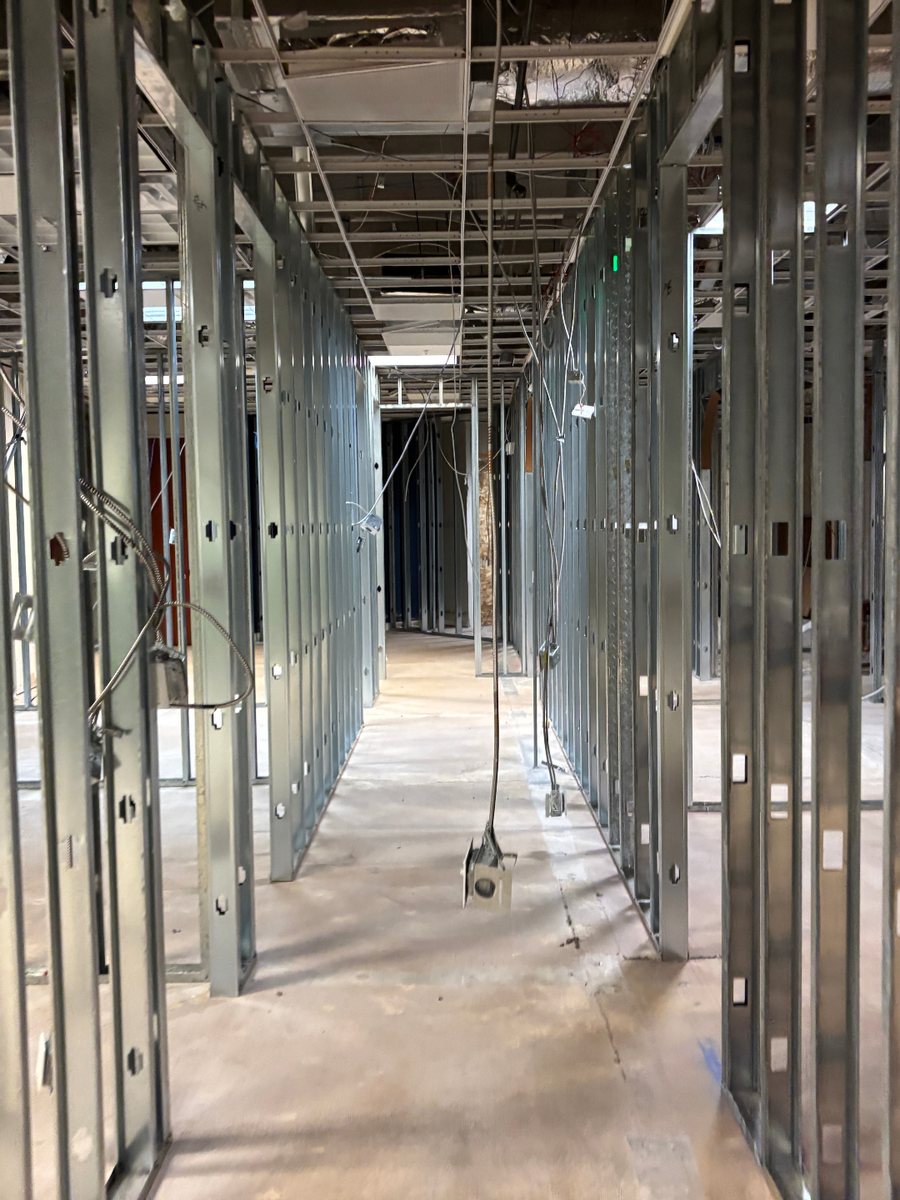 Light-gauge metal stud partitions framing a commercial corridor