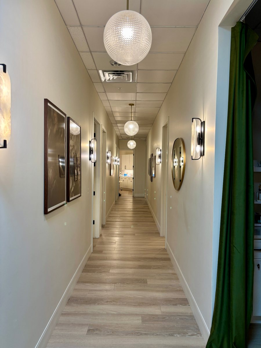 Completed office corridor with flooring, wall sconces, pendant lights and artwork